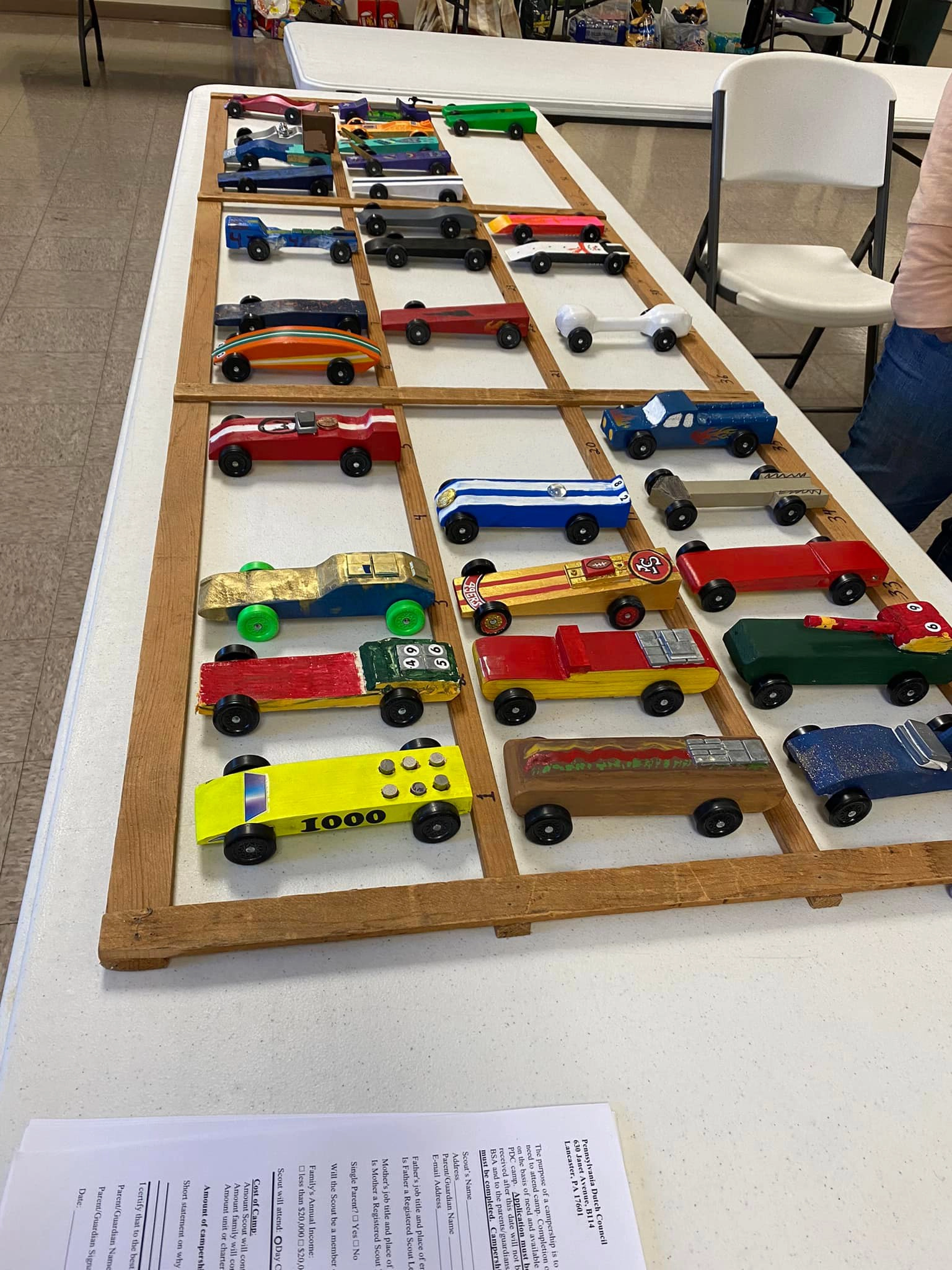 A photo of the 'car rack' table full of Pinewood Derby cars.